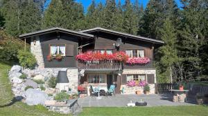 a house with flowers on the balcony of it at La Drossa in Lenzerheide