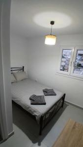 a bedroom with a bed with two towels on it at Harbor View Apartment Athens in Piraeus