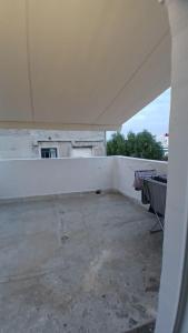 an empty room with a white wall at Harbor View Apartment Athens in Piraeus