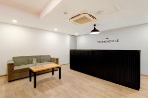 a waiting room with a couch and a table at Hotel O Crowninn in Faridabad