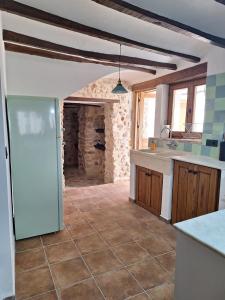 a kitchen with a refrigerator and a tile floor at Casa Trilles in Azuébar