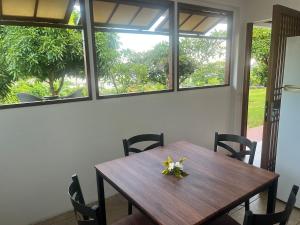 a dining room table with chairs and windows at Atea Fare Pāmata'i in Faaa