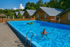 a couple of people in a swimming pool at Ośrodek Wypoczynkowy Słońce Dąbki in Dąbki