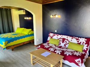 a living room with a couch and a table at Atea Fare Pāmata'i in Faaa