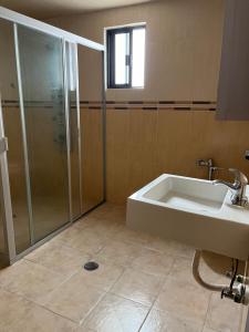 a bathroom with a shower and a tub and a sink at La Casa de Ikal Zacatlán in Zacatlán +5 photos