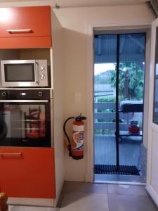 a kitchen with a microwave and a door to a patio at Gite au pied de la montagne avec tous commerces in Arette +19 photos