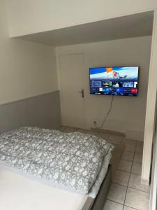 a bedroom with a bed and a flat screen tv on the wall at T3 duplex Cosy Centre-ville Longjumeau Proche RER TGV Orly in Longjumeau