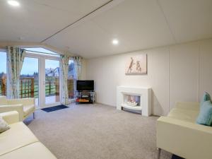 a living room with white furniture and a fireplace at The Paddocks - Uk7112 in Alloa