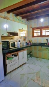 a kitchen with white cabinets and a counter top at Sitio Ziriguidum in Nova Friburgo