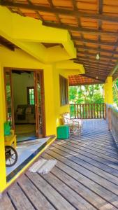 a porch of a house with yellow walls at Sitio Ziriguidum in Nova Friburgo +3 photos