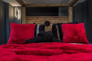 a bed with a red blanket and red pillows at The Midnight Parlour in Leeds