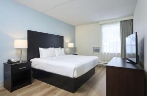 a hotel room with a bed and a television at Canad Inns Destination Centre Windsor Park in Winnipeg