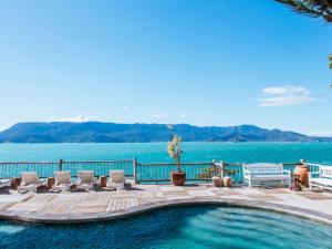 a swimming pool with chairs and the water at Vilatoro Guest House in Ilhabela +32 photos