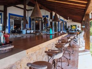 a bar with a row of stools in a restaurant at Vilatoro Guest House in Ilhabela