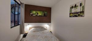 a bedroom with a bed with two pictures on the wall at F2 - Zen & Cozy in Épinal