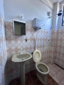 a bathroom with a toilet and a sink and a tv at Hotel Ideal in Boa Vista +37 photos