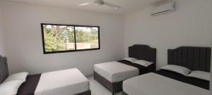 a bedroom with two beds and a window at Villa Luna Hotel-Eventos in Carmen de Apicalá