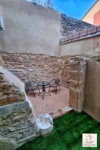 a patio with two chairs and a table next to a wall at Le Petit Cocon Cozy studio proche de Lyon in Couzon-au-Mont-dʼOr +13 photos