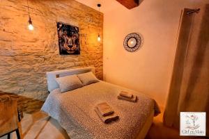 a bedroom with a bed in a stone wall at Le Petit Cocon Cozy studio proche de Lyon in Couzon-au-Mont-dʼOr