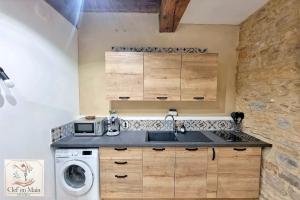 a kitchen with a sink and a washing machine at Le Petit Cocon Cozy studio proche de Lyon in Couzon-au-Mont-dʼOr