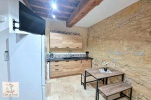 a kitchen with a table and a stone wall at Le Petit Cocon Cozy studio proche de Lyon in Couzon-au-Mont-dʼOr