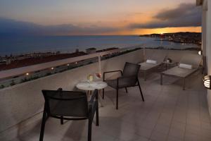 a balcony with a table and chairs and a view of the ocean at Melia Sitges in Sitges