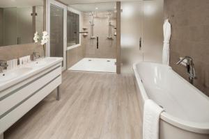 a bathroom with two sinks and a tub and a shower at Melia Sitges in Sitges