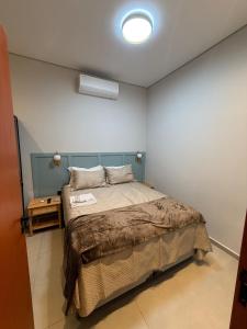 a bedroom with a bed with a blue headboard at Hospedaria da Estação in Espirito Santo Do Pinhal