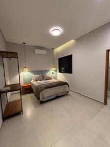 a bedroom with a bed and a mirror in it at Hospedaria da Estação in Espirito Santo Do Pinhal +3 photos