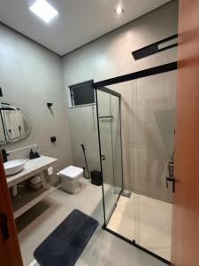 a bathroom with a shower and a toilet and a sink at Hospedaria da Estação in Espirito Santo Do Pinhal
