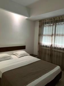 a bedroom with a large bed with a window at Comfortable and Fresh Apartment in Tunis