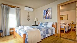 a hotel room with a bed and a mirror at Auberge Ayer's Cliff in Ayers Cliff