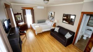 a living room with a couch and a tv at Auberge Ayer's Cliff in Ayers Cliff
