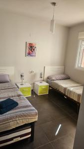 a room with two beds and two tables in it at Lazy Wave Apartment in Torrevieja
