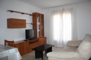 sala de estar con sofá blanco y TV en Barceloneta UPartments, en Figueres