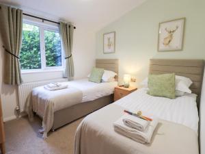 a bedroom with two beds and a window at Unique Luxury Lodge in Windermere