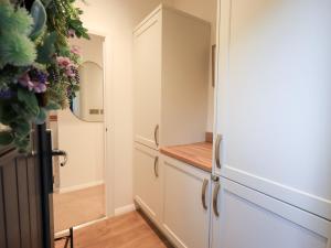 a kitchen with white cabinets and a mirror at Unique Luxury Lodge in Windermere +45 photos