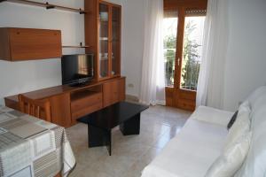 1 dormitorio con 1 cama, TV y mesa en Barceloneta UPartments, en Figueres