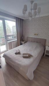 a bedroom with a large bed with two towels on it at Królewski Apartament nad Zegrzem 206 Luksus in Serock