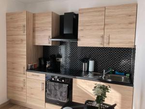 a kitchen with wooden cabinets and a sink at Tiny House Ô Secret du Wérihay in Spa