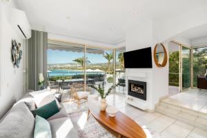 a living room with a couch and a fireplace at Beachfront Villa Mare with Jaccuzi and Infinity Pool in Kissonerga