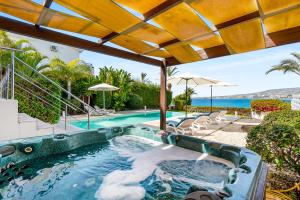 an outdoor hot tub with a view of the ocean at Beachfront Villa Mare with Jaccuzi and Infinity Pool in Kissonerga