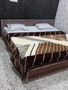 a bed with a brown and white comforter at Hotel p p inn in Agra