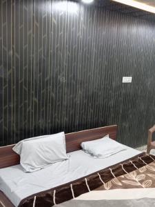 a bed in a room with a black wall at Hotel p p inn in Agra
