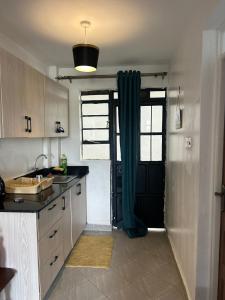 a kitchen with a sink and a black door at JOJO Staycations in Rungiri