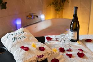 a bottle of wine sitting next to two towels with hearts at Suite Climatisé Bali SPA et sauna privé pour 2-Châteaux de la Loire in Cour-Cheverny