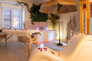 a room with a table and a chair and an umbrella at Suite Climatisé Bali SPA et sauna privé pour 2-Châteaux de la Loire in Cour-Cheverny