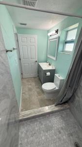 a bathroom with a white toilet and a window at Modern 3BR Home in secure neighborhood with Free Parking & WiFi in Riverview +6 photos