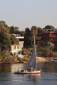 a small boat with a sail in the water at Reagan House in Aswan