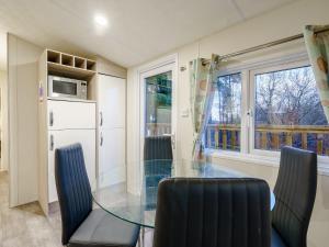 a dining room with a glass table and chairs at The Paddocks - Uk7112 in Alloa